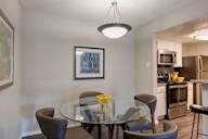 A modern dining room with a glass table and chairs.