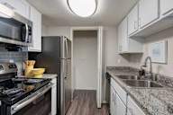 A kitchen with a black stove top oven and a black refrigerator.