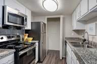 Kitchen with a black stove top oven and a black microwave.