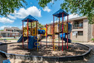 A playground with a blue and yellow slide and a red and yellow structure.