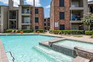 A swimming pool in front of apartment buildings.