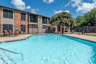 A swimming pool in front of apartment buildings.