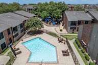 A swimming pool surrounded by a fence and chairs.