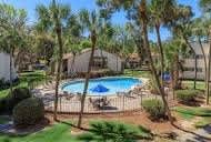 Pool surrounded by a fence and trees.