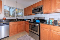 Kitchen with wooden cabinets and a black countertop.