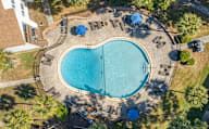 Aerial view of a swimming pool surrounded by lounge chairs and umbrellas.