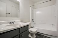 A white toilet sits next to a sink in a bathroom.