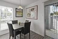A dining room with a table and chairs.