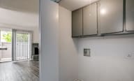 A kitchen area with a white wall and a window with blinds.
