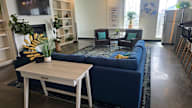 A blue couch with a white table in front of it.
