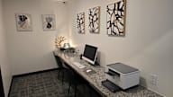 A room with a desk, chair, and artwork on the wall.