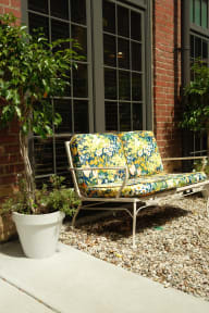 a bench sitting outside of a house with a potted plant