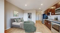 A bedroom with a bed and a green knitted throw.