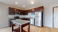 A kitchen with a granite countertop and stainless steel appliances.
