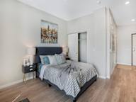 A bedroom with a large bed and a painting on the wall.