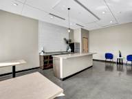 A modern office space with a reception desk and two chairs.