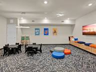 A room with tables, chairs and a whiteboard.