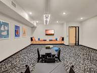 A room with a patterned carpet and a long couch.