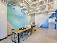 A room with a table and chairs and a blue wall.