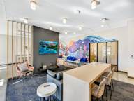 A modern office space with a large mural on the wall.