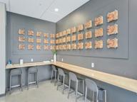A room with a long table and chairs with a wall of wood planks on the wall.