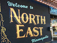 A sign that says "Welcome to North East Minneapolis" is displayed.