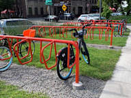 A bike is locked to a red bike rack.