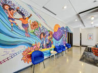 A mural of a man and woman dancing with flowers and a sun in the background.
