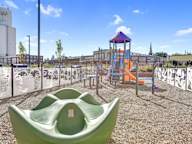 A playground with a green slide and a purple and orange tower.