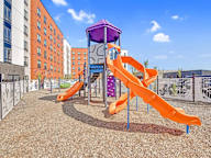 A playground with a purple and orange slide.