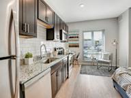 A modern kitchen with a refrigerator, sink, and stove.