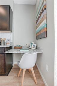 A kitchen with a white chair and a marble table.