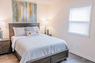 a bedroom with a bed and a painting on the wall