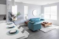 a living room with a blue couch and a table and chairs