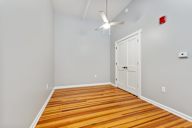 A room with a white door and a ceiling fan.