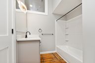 White bathroom with a sink and a bathtub.