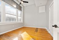 Room with a wooden floor and a ceiling fan.