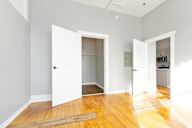 Room with a white door and a wooden floor.