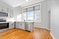 A kitchen with wooden floors and stainless steel appliances.