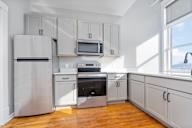A kitchen with a refrigerator, oven, microwave, and cabinets.