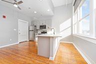 A kitchen with a white island and wooden floors.