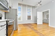 A kitchen with wooden floors and a refrigerator.