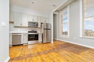 A kitchen with wooden floors and stainless steel appliances.