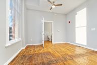 A room with a wooden floor and a ceiling fan.
