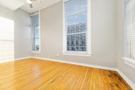 A room with wooden floors and a window with blinds.