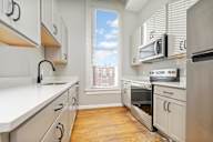 A kitchen with white cabinets and a stainless steel oven.