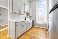 A kitchen with wooden floors and white cabinets.