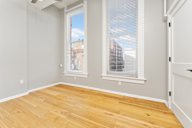 A room with a window and wooden flooring.