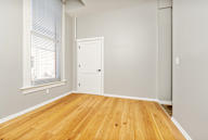 A room with a wooden floor and a white door.