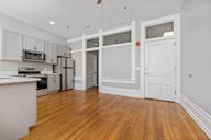 A kitchen with wooden floors and white walls.